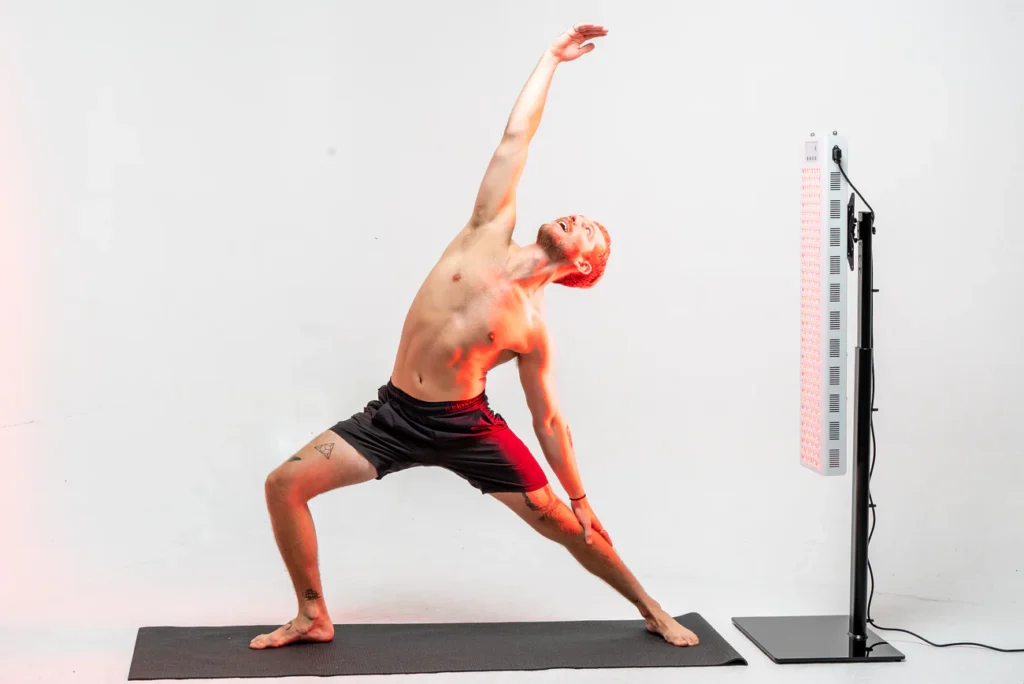 man doing yoga while absorbing redlight therapy